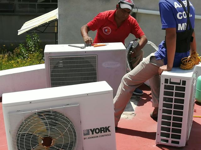 Técnicos de AASMA dando servicio a condensadoras York y Carrier en una azotea