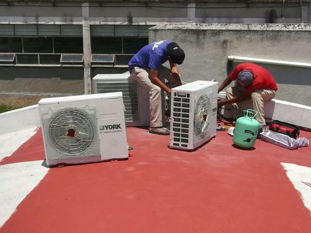 Equipo de AASMA reubicando condensadoras de minisplit en una azotea